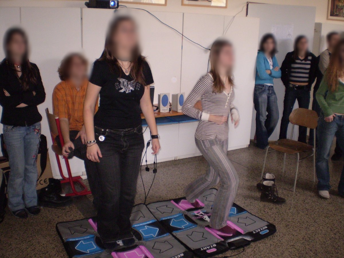 Two high school students dance on pads while classmates watch, in Slovakia