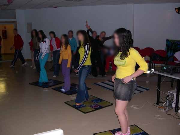 A room full of kids dancing on floor pads at an after-school program in Spain