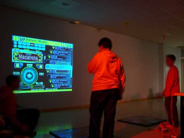 Kids at an after-school program in Spain dance to a game projected on the wall